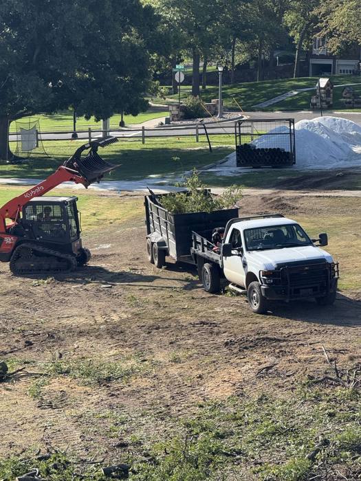 Skid steer and truck prepping a yard