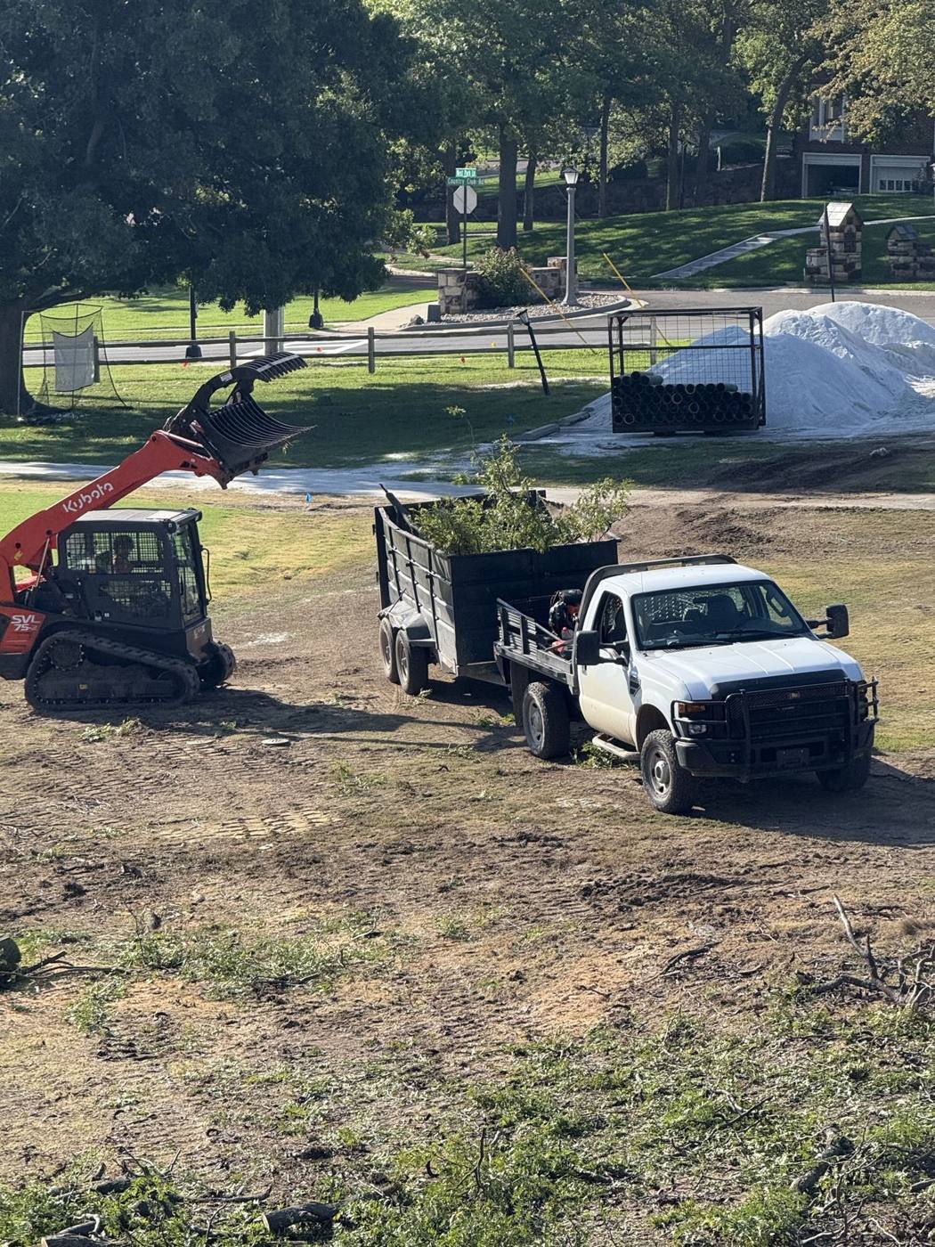 Skid steer and truck prepping a yard