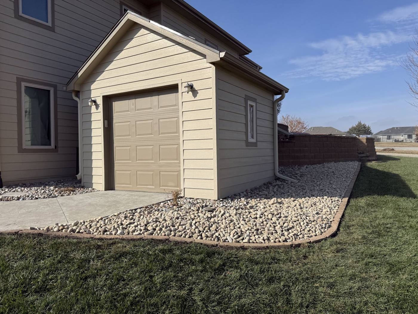 Rock bed with steel edging along a garage