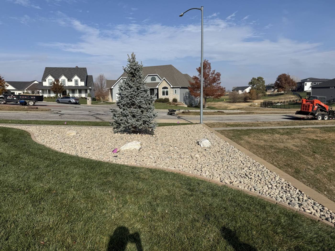 Finished rock bed with spruce on a corner lot